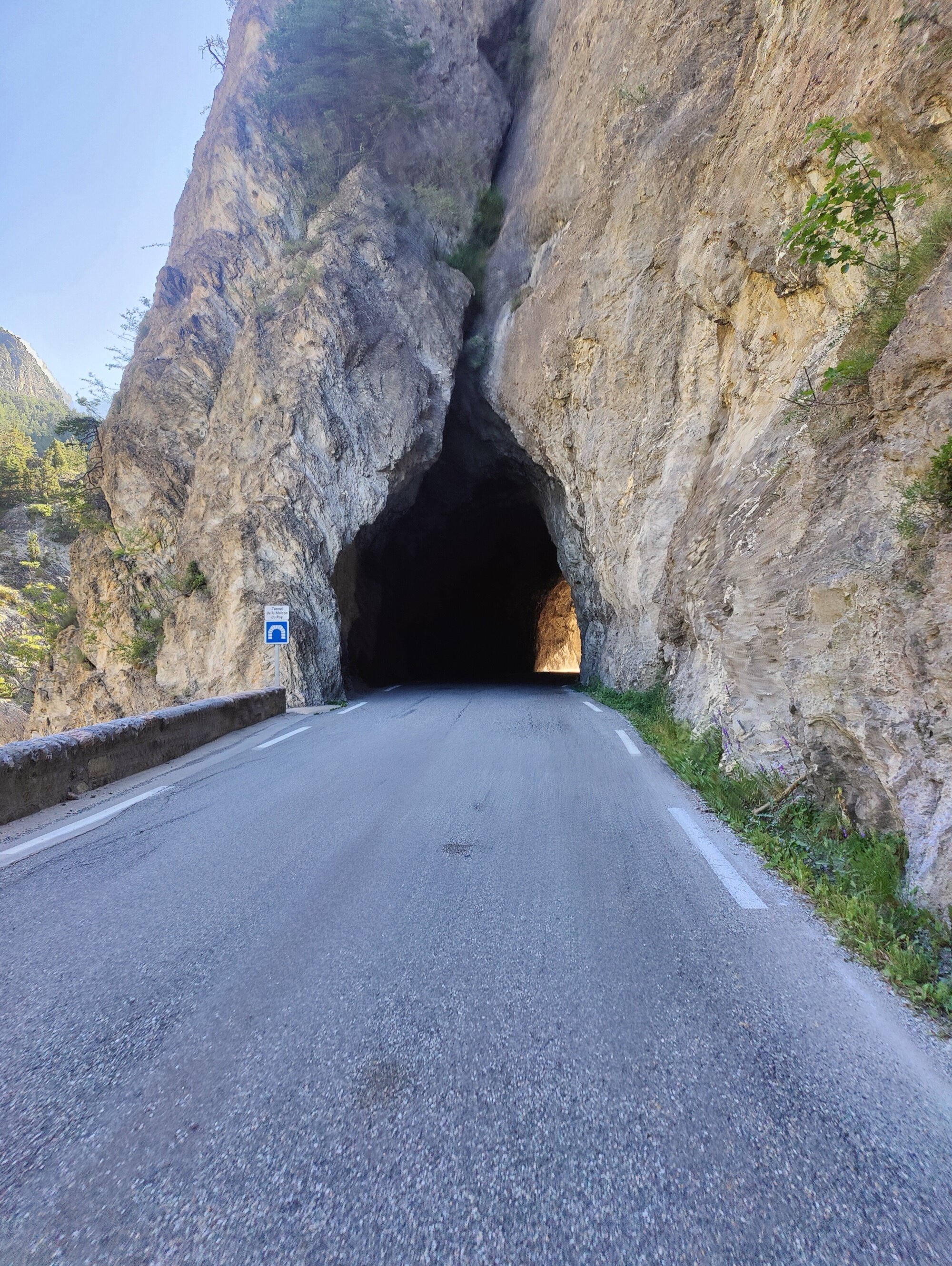Tunnel percé à l'explosif dans la Combe du Queyras — roche brute, pénombre, le Guil qui gronde en contrebas