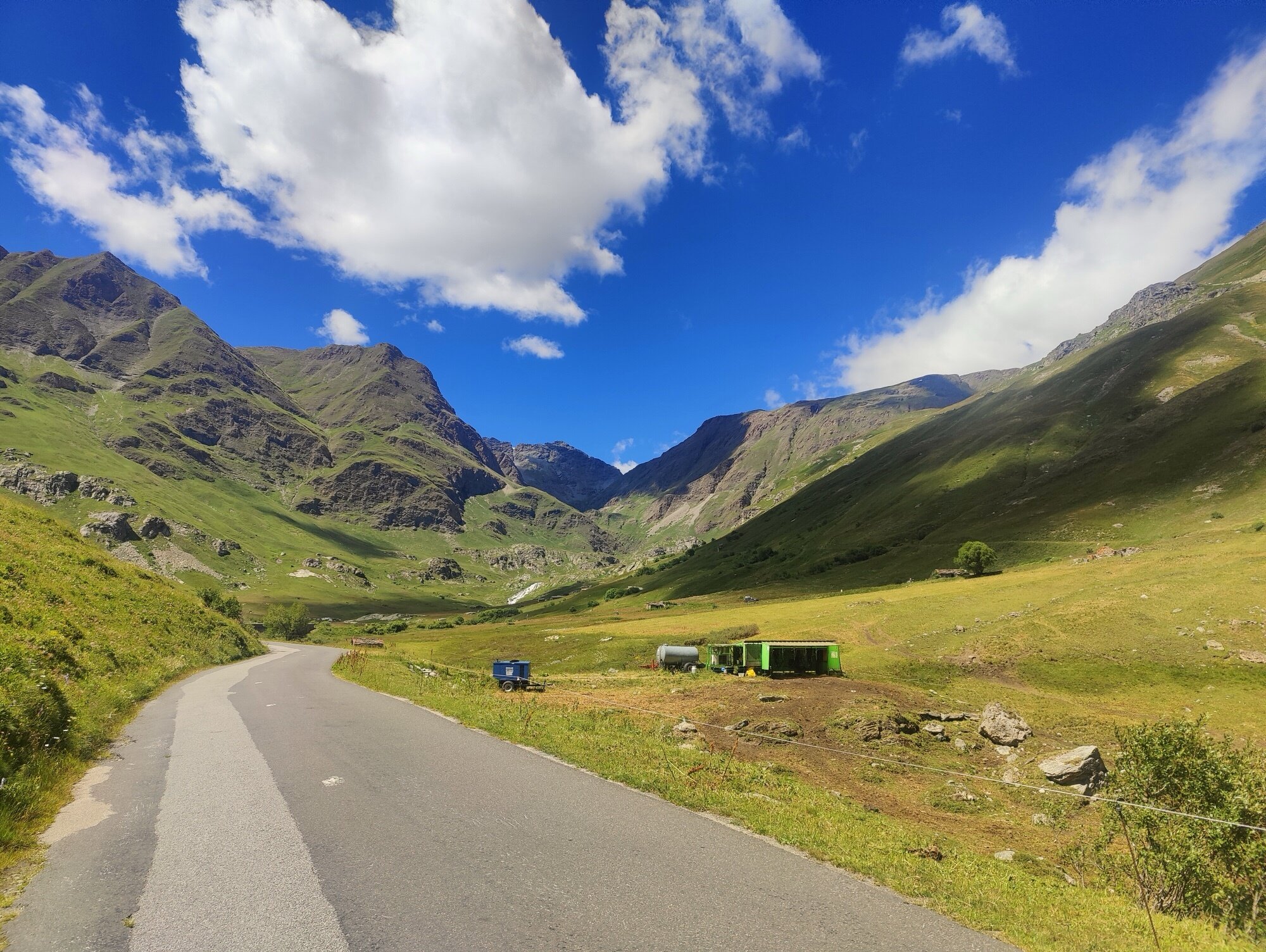 La route descendant dans la haute vallée alpine après le sommet
